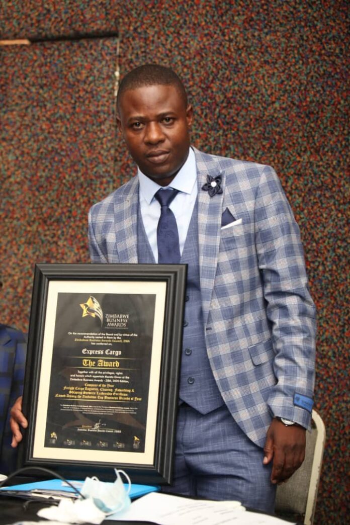 Dr Paul Shambare holds a business award he received recently