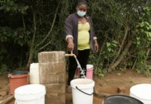 Josephine Mbayo uses one of the newly installed taps in Tongogara refugee camp to fill a bucket of water. The taps are part of a piped water system that uses solar power and high-capacity boreholes. © UNHCR/Tsvangirayi Mukwazhi
