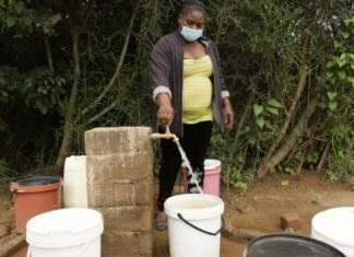 Josephine Mbayo uses one of the newly installed taps in Tongogara refugee camp to fill a bucket of water. The taps are part of a piped water system that uses solar power and high-capacity boreholes. © UNHCR/Tsvangirayi Mukwazhi