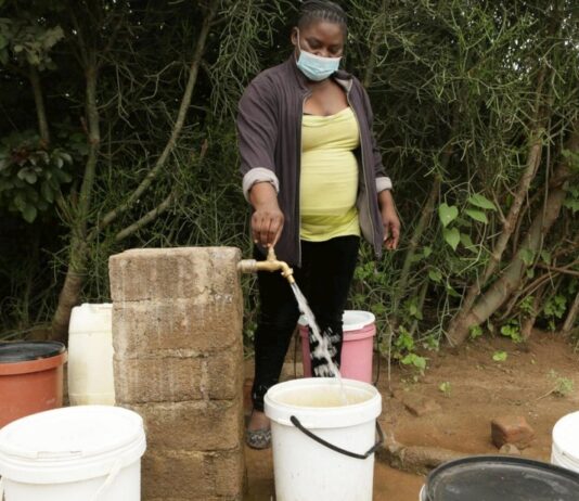 Josephine Mbayo uses one of the newly installed taps in Tongogara refugee camp to fill a bucket of water. The taps are part of a piped water system that uses solar power and high-capacity boreholes. © UNHCR/Tsvangirayi Mukwazhi
