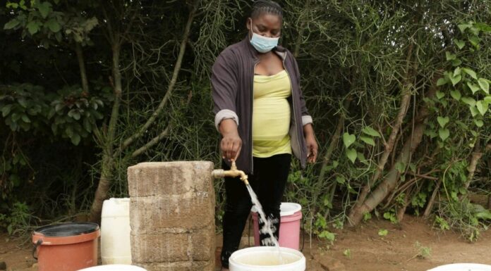 Josephine Mbayo uses one of the newly installed taps in Tongogara refugee camp to fill a bucket of water. The taps are part of a piped water system that uses solar power and high-capacity boreholes. © UNHCR/Tsvangirayi Mukwazhi