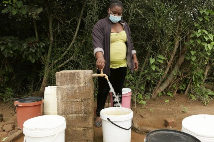 Josephine Mbayo uses one of the newly installed taps in Tongogara refugee camp to fill a bucket of water. The taps are part of a piped water system that uses solar power and high-capacity boreholes. © UNHCR/Tsvangirayi Mukwazhi