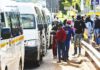 Commuters wear protective face masks as they line up for taxi vans in Pretoria, South Africa, on Feb. 8, 2021. WALDO SWIEGERS/BLOOMBERG