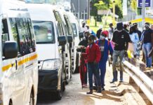 Commuters wear protective face masks as they line up for taxi vans in Pretoria, South Africa, on Feb. 8, 2021. WALDO SWIEGERS/BLOOMBERG