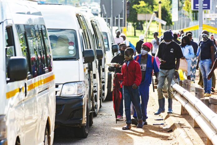 Masks Commuters wear protective face masks as they line up for taxi vans in Pretoria, South Africa, on Feb. 8, 2021. WALDO SWIEGERS/BLOOMBERG