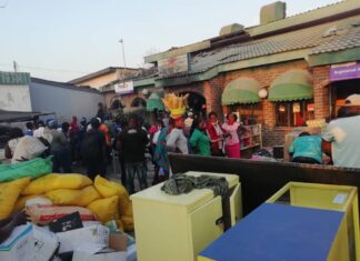 Vendors and other residents from Karoi mingle in front of the building that was gutted in yet another fire incident in Karoi. Mashonaland West has recorded an increased number of fire incidents during this year's fire season
