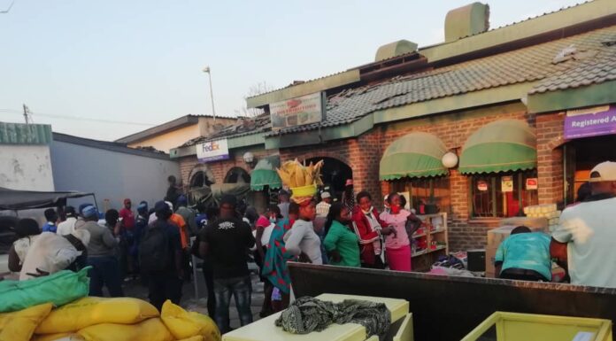 Vendors and other residents from Karoi mingle in front of the building that was gutted in yet another fire incident in Karoi. Mashonaland West has recorded an increased number of fire incidents during this year's fire season